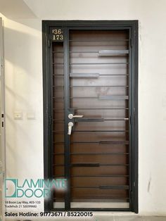 an empty room with a wooden door and black frame