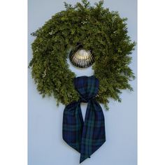 a wreath with a blue and green tartan scarf tied around it's neck