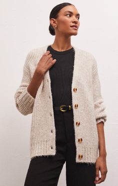 You’ll get all the cozy feels from the Josie Cozy Cardigan! Made using our oh-so-soft and chunky Sweater Knit, this heathered, relaxed cardigan features faux horn buttons so it can be worn open or closed, and rib cuffs. Throw it on over any outfit to elevate it instantly. Fabric Content: 60% Acrylic 20% Nylon 20% Polyester Womens Chunky Sweater, Lounge Bra, Big Sweaters, Cozy Cardigan, White Cardigan, Chunky Sweater, Sweater Knit, Ladies Boutique, Contemporary Fashion