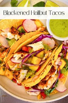 a white plate topped with tacos covered in meat and veggies