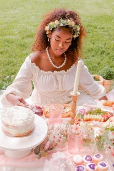 a woman sitting at a table with a cake in front of her