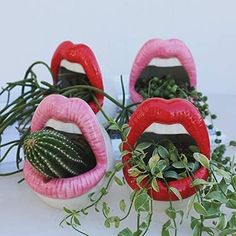 three fake lips with plants growing out of them