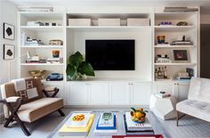 a living room filled with furniture and a flat screen tv mounted on a wall above it