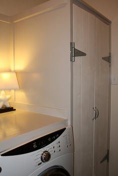 a washer and dryer in a small room with a lamp on the side