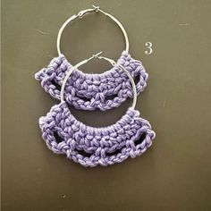 a pair of crocheted hoop earrings sitting on top of a table