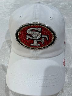 49ers WOMENS ADJUSTABLE STRAP BACK '47 RELAXED FIT WHITE HAT LARGE CLEAR SWAROVSKI CRYSTALS BODER THE PATCH AND GIVE DIMENSION TO THE SF LETTERS 300+ RED AND GOLD AND CLEAR CRYSTALS IN VARIOUS SIZES, FILL IN THE LOGO FOR MAX BLING!! HAND EMBELLISHED PRECISE CRYSTAL PLACEMENT AND ATTENTION TO DETAIL ALSO AVAILABLE IN BLACK OR RED Crystal Placement, 2024 Manifestations, 49ers Outfit, Rhinestone Football, Bling Hat, 90s Outfits, Nfl 49ers, 49ers Fans, Rhinestone Projects