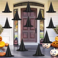 a front porch decorated for halloween with pumpkins and witch hats on the steps,