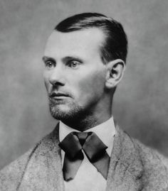 an old photo of a man in a suit with a bow tie on his neck