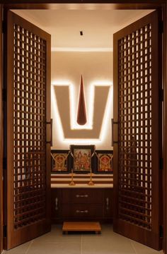 an open door leading into a bathroom with lights on the ceiling and wooden doors in front of it