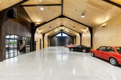 three cars are parked in an empty car garage with wood paneling on the walls