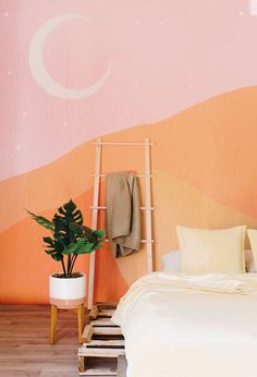 a bedroom with an orange and pink wall, white bedding and a ladder leaning against the wall