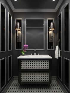 a black and white bathroom with two sinks, mirrors and lights on the wall above it