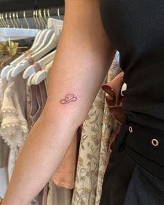 a woman's arm with a small heart tattoo on the left side of her arm