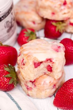 strawberry shortcakes with icing and strawberries next to them on a towel