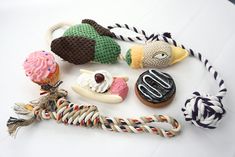 several knitted objects are arranged on a white table top, including doughnuts and candy