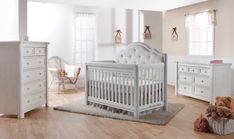 a baby's room with white furniture and wooden floors