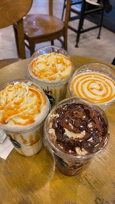 four desserts in plastic cups on a table