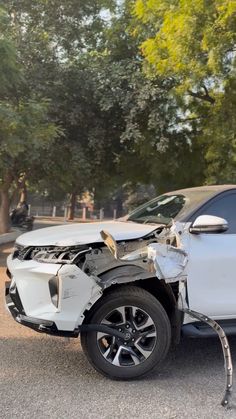 a car that has been involved in an accident with its hood up and the front wheel missing