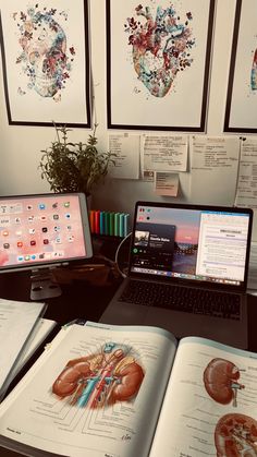 an open book sitting on top of a desk next to a laptop computer and monitor