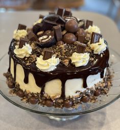 a cake with chocolate and cream toppings on a glass plate