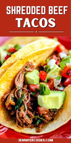 shredded beef tacos with avocado, tomatoes and cucumber on a red plate