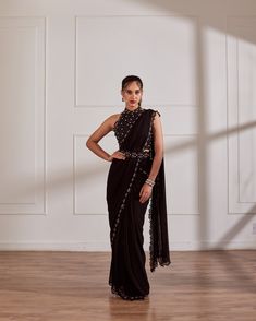 Black halter blouse with pre draped saree having hand embroidered border and detatchable belt.Black predraped saree set with belt No. of pieces in a set: 3 Color: Black Fabric Composition: Opada silk, georgette, organza Lining Material: Shantoon Closure used: Back hook in blouse and side zip in saree. Dress Length : Full Silhouette: Saree Neck type : Halter neck Sleeve Length: Sleeveless Waistline: High waist Prints/ Pattterns : Plain Delivery Time: 20-25 days Halter Blouse Saree, Halter Neck Saree, Pre Draped Saree, Pleated Saree, Draped Saree, Halter Blouse, Drape Saree, Black Saree, Embroidered Border