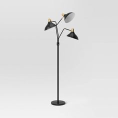 the three light floor lamp is black and has two lamps on each side of it