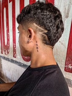 a person with a tattoo on their left side of the ear and behind them is a red sign