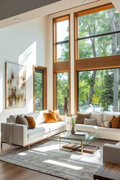 a living room filled with lots of furniture next to large windows on top of a hard wood floor