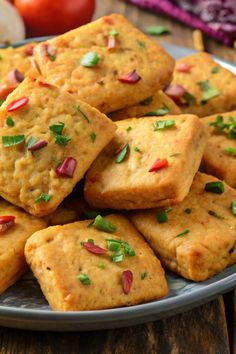 a plate full of crackers with toppings on them sitting on a wooden table