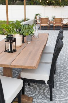 a wooden table with chairs and plants on it