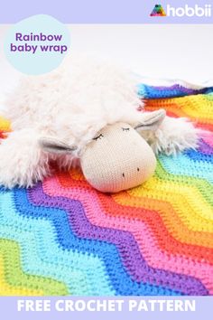 a crocheted sheep laying on top of a rainbow blanket with text overlay reading rainbow baby wrap free crochet pattern