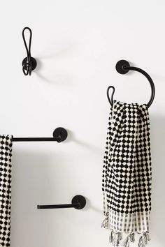 two black and white checkered towels hanging on the wall next to towel racks with hooks