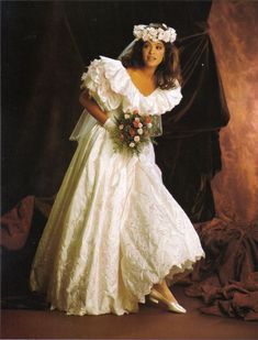 a woman in a wedding dress posing for a photo