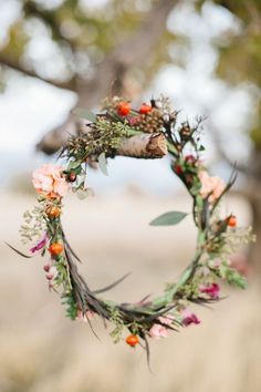 a wreath with flowers hanging from it's side and the words abencoado seja seu dia