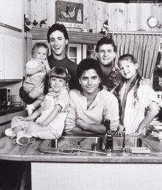 an old black and white photo of a family posing for a picture in the kitchen