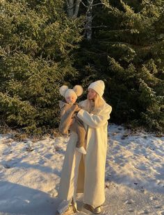 a woman holding a child in the snow