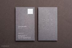 two gray business cards sitting side by side on a brown surface with the words dot bar floor printed on it