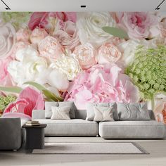 a living room with flowers on the wall and couches in front of it,