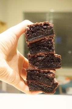 a person holding up some brownies in their hand