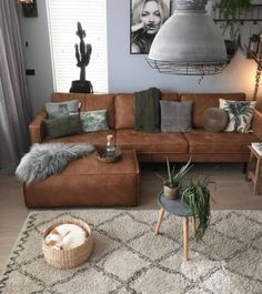 a living room filled with lots of furniture and plants on top of a white rug