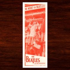 an old poster advertises the beatles in red and white on a wood background