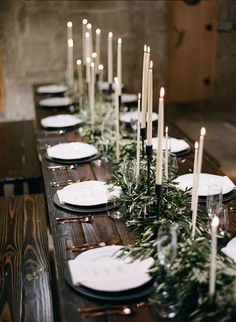 a long table with candles and plates on it