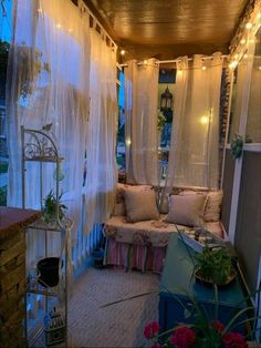 an outdoor room with curtains and lights on the ceiling