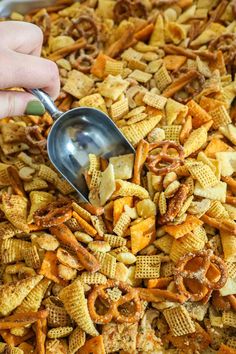 a person scooping up some cheetos into a large casserole dish