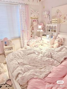 a bedroom with pink and white bedding and teddy bears on the wall above it