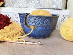 Bowl with yarn cutout and 3 needle holes and the personalized name Julie on it holding a ball of yellow yarn and connected to a crochet hook and project Knit Gifts, Gifts For Knitters, Ceramic Yarn Bowl, Handmade Yarn, Crafter Gift, Yarn Bowl, Crochet Lovers, Knitting Gift, Pottery Making