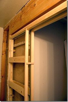 the bottom half of a closet is being built with wooden shelves and shelving units