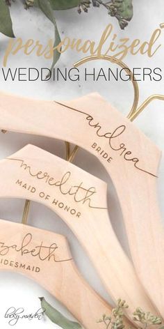 three wooden wedding hangers with names on them