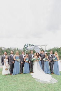 a group of people standing next to each other on top of a grass covered field